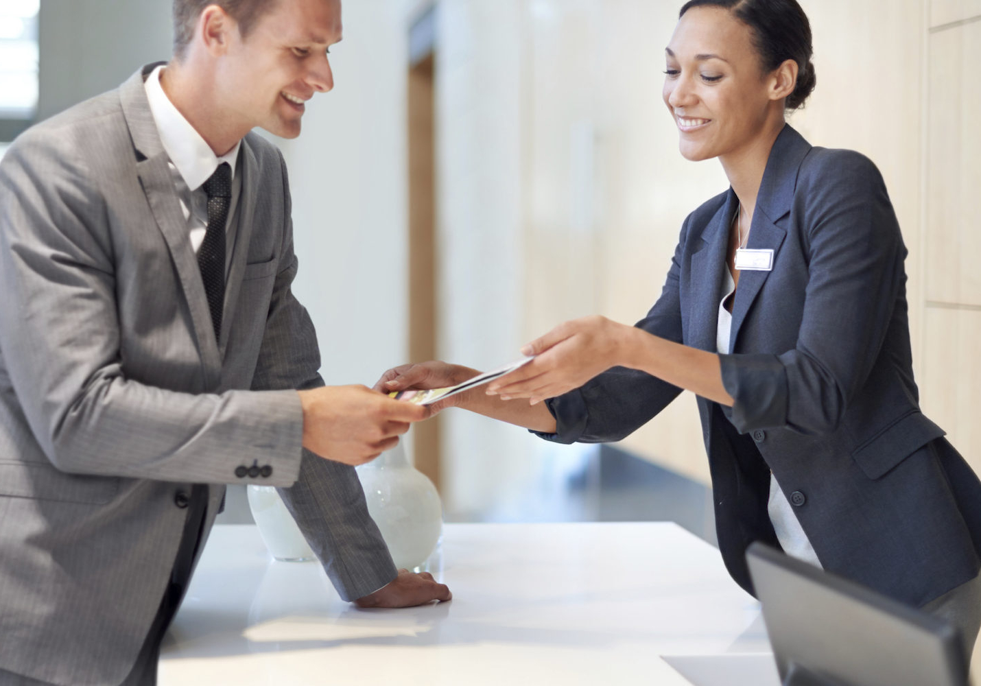 A handsome young man handing over a credit card to a woman