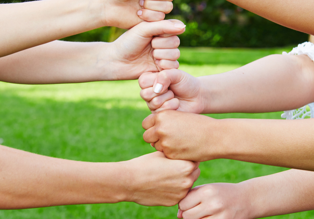 Team building tower in cooperation with their fists in nature